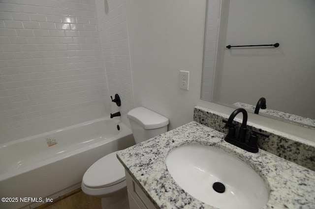 full bathroom with tiled shower / bath, vanity, and toilet