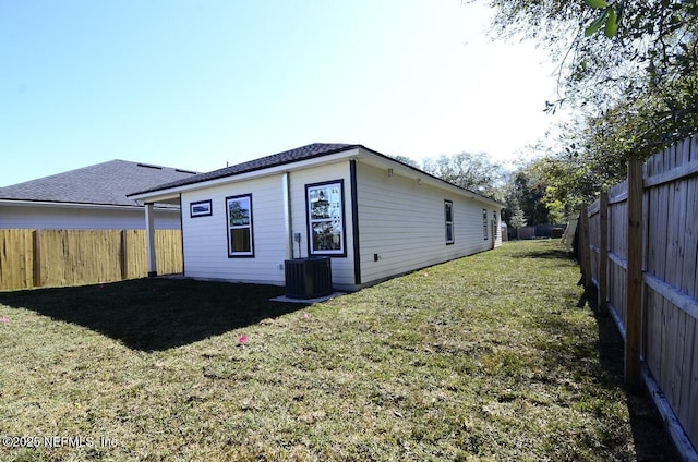 back of property featuring a lawn and central AC