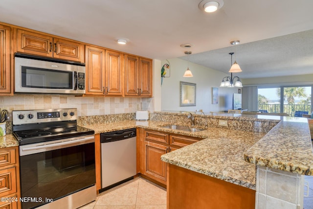 kitchen with light stone counters, sink, appliances with stainless steel finishes, and tasteful backsplash