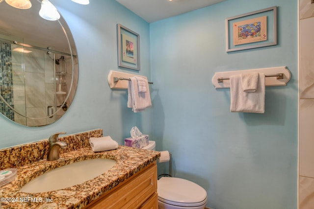 bathroom featuring an enclosed shower, vanity, and toilet