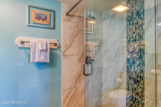 bathroom featuring toilet and a shower with door