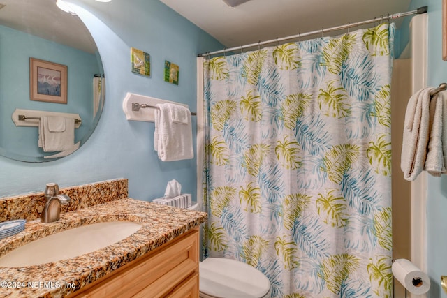 bathroom with a shower with curtain, vanity, and toilet