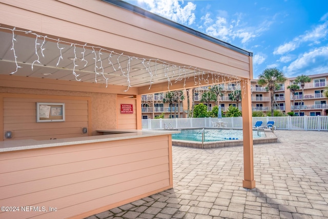 view of swimming pool featuring a patio area and a bar