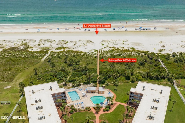 bird's eye view featuring a water view and a beach view