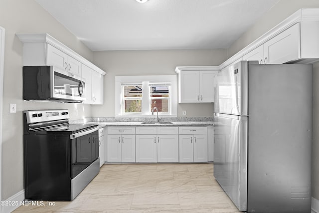 kitchen featuring stainless steel appliances, sink, white cabinets, and light stone counters