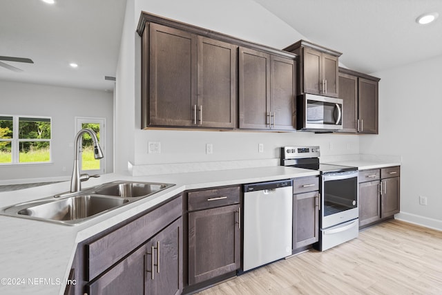 kitchen featuring light wood finished floors, appliances with stainless steel finishes, light countertops, dark brown cabinets, and a sink