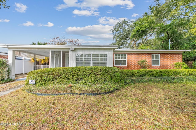 view of front of home with a carport and a front lawn