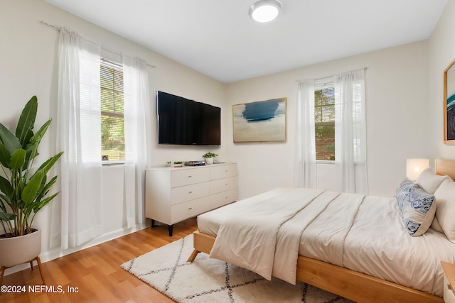 bedroom featuring multiple windows and light wood-type flooring