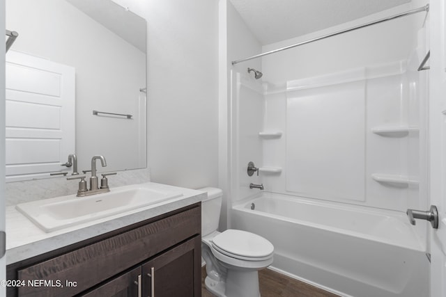 full bath with washtub / shower combination, wood finished floors, vanity, and toilet