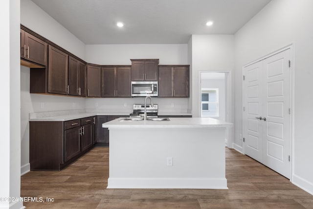 kitchen with dark brown cabinets, stainless steel appliances, and a sink