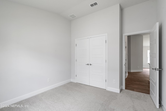 unfurnished bedroom with baseboards, a closet, visible vents, and carpet flooring