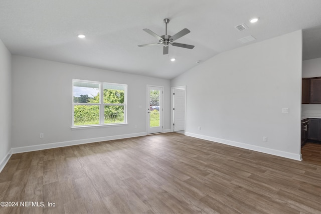 unfurnished living room featuring baseboards, visible vents, lofted ceiling, wood finished floors, and recessed lighting