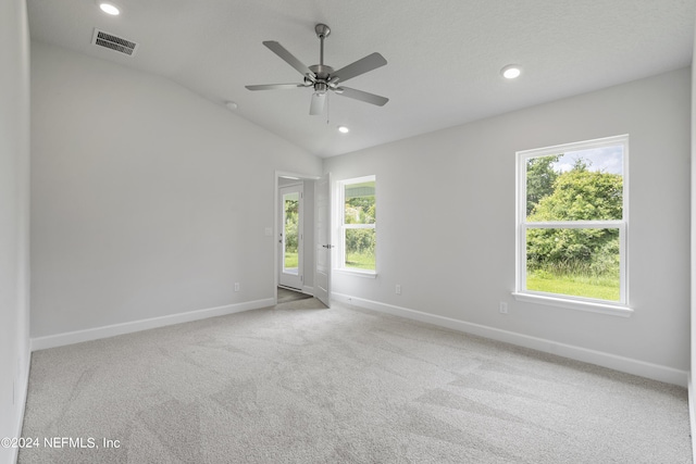 spare room featuring recessed lighting, carpet flooring, visible vents, baseboards, and vaulted ceiling