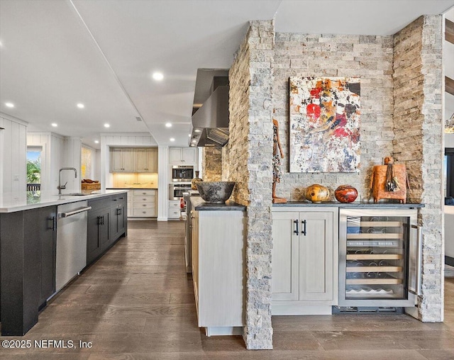 kitchen featuring sink, dishwasher, dark hardwood / wood-style floors, island range hood, and beverage cooler