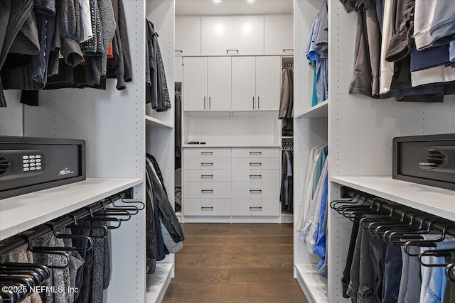 walk in closet with dark hardwood / wood-style floors