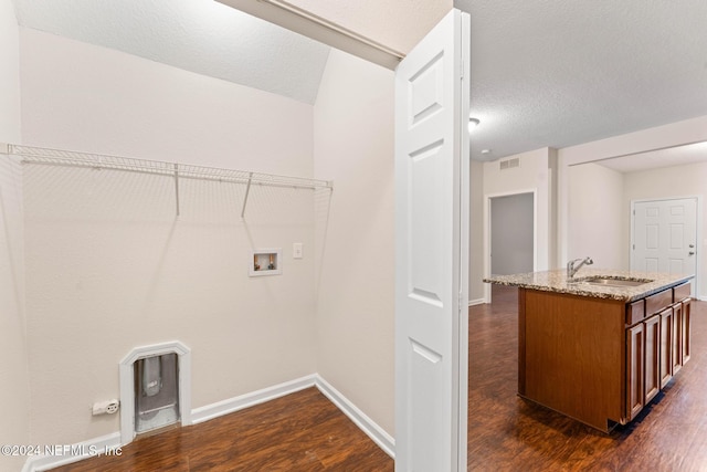 laundry area with dark hardwood / wood-style flooring, hookup for a washing machine, a textured ceiling, and sink