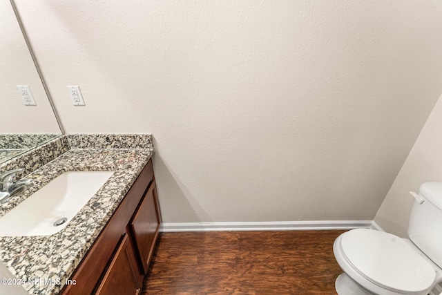 bathroom featuring wood-type flooring, vanity, and toilet