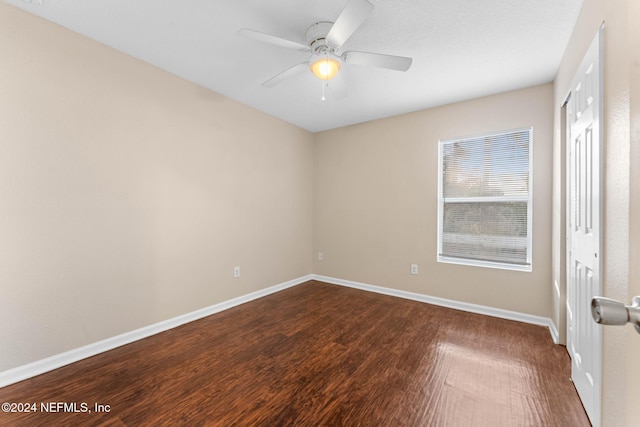 spare room featuring dark hardwood / wood-style flooring and ceiling fan