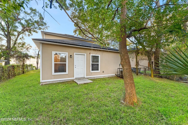 rear view of property with a lawn