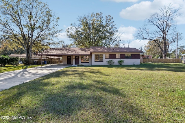 ranch-style home featuring a carport and a front yard