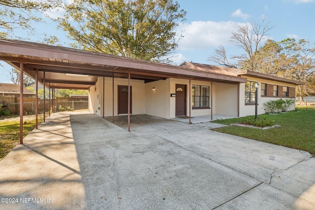 ranch-style home with a front yard and a carport