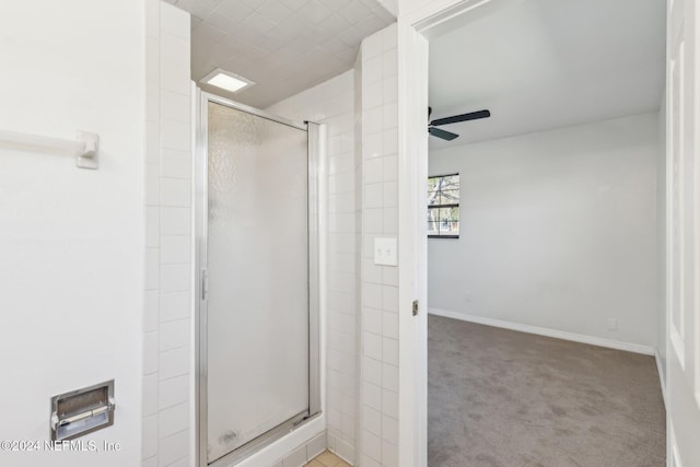 bathroom featuring ceiling fan and a shower with shower door