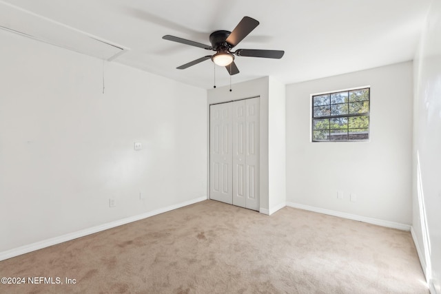 unfurnished bedroom featuring a closet, ceiling fan, and light colored carpet