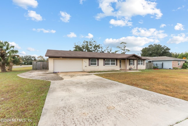 single story home featuring a garage and a front lawn