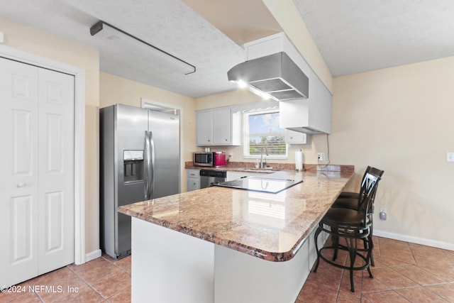 kitchen with sink, stainless steel appliances, kitchen peninsula, a breakfast bar area, and light tile patterned floors