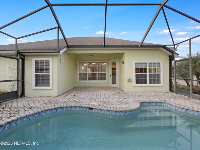 rear view of property featuring glass enclosure and a patio area