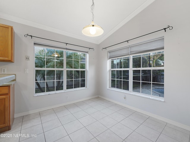 unfurnished dining area featuring ornamental molding, lofted ceiling, and light tile patterned floors