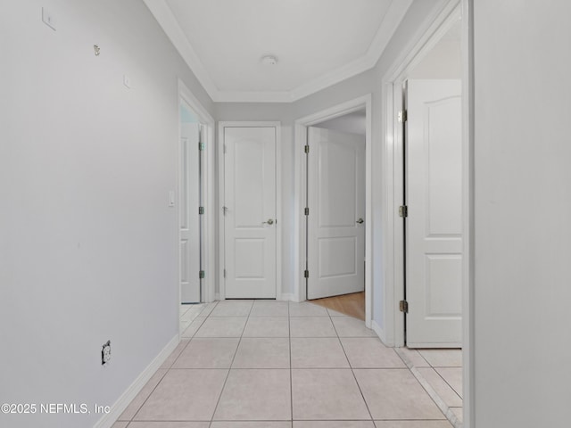 hall with crown molding and light tile patterned floors