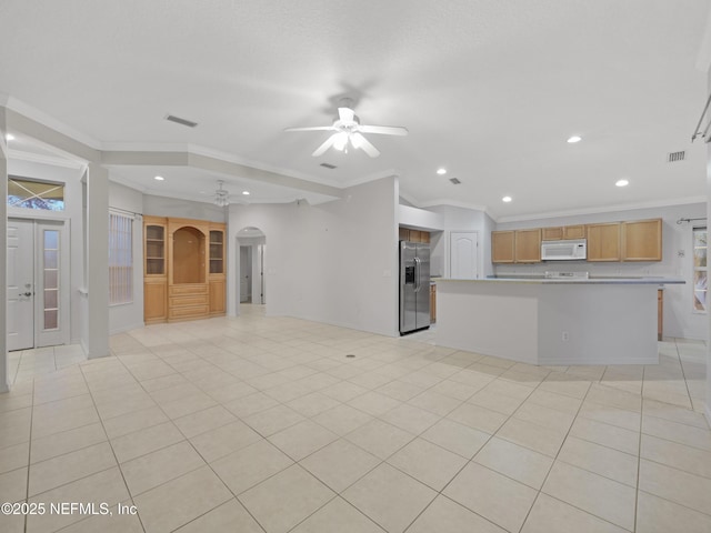 unfurnished living room featuring light tile patterned flooring, ceiling fan, and ornamental molding