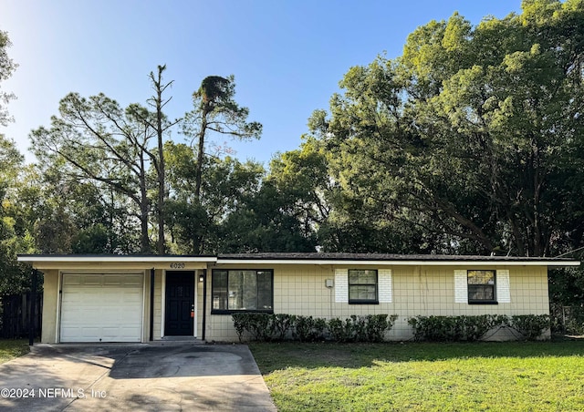 ranch-style house featuring a garage and a front lawn