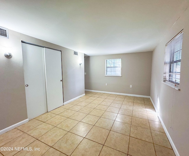 unfurnished bedroom with light tile patterned floors and a closet