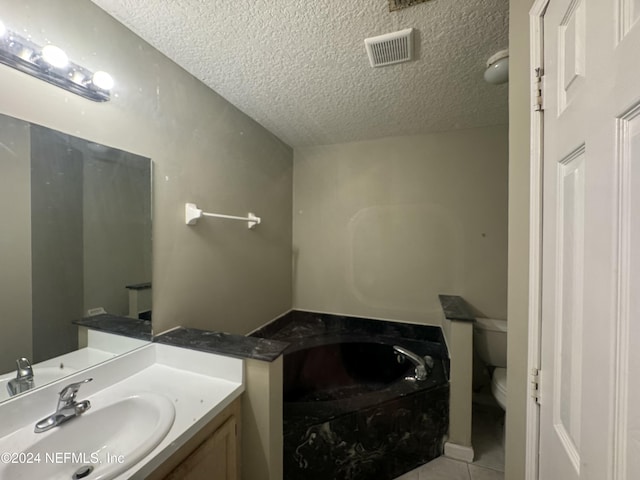 bathroom with tile patterned flooring, vanity, toilet, and a textured ceiling