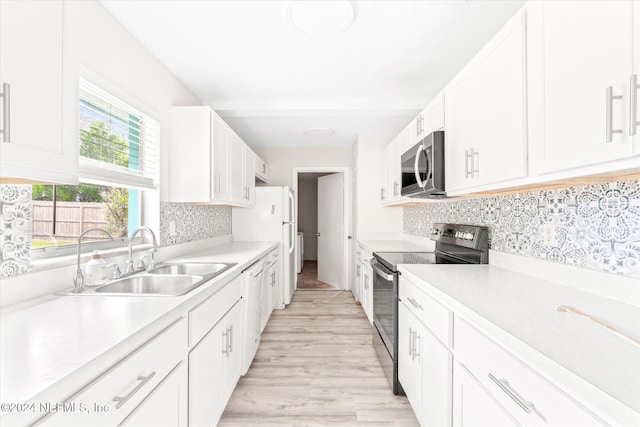 kitchen featuring light wood-type flooring, backsplash, stainless steel appliances, sink, and white cabinets