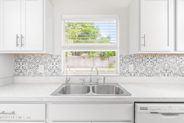 kitchen featuring dishwasher, tasteful backsplash, white cabinetry, and sink