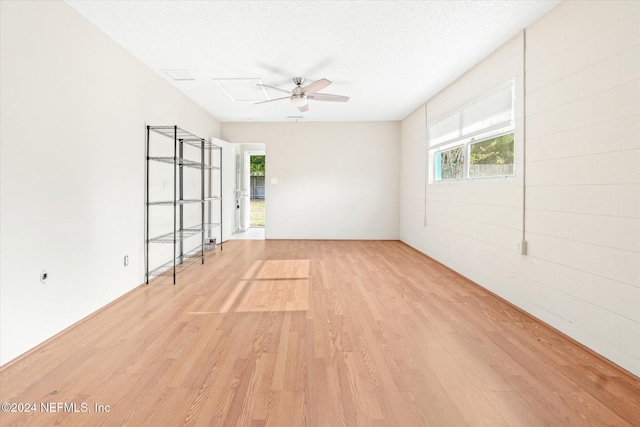 spare room featuring light hardwood / wood-style floors and a textured ceiling