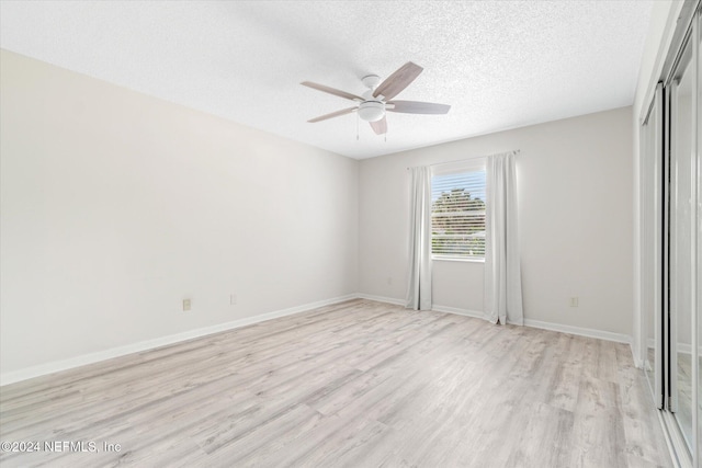 unfurnished bedroom featuring ceiling fan, a textured ceiling, and light wood-type flooring