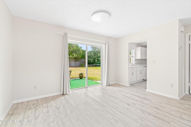 empty room featuring a textured ceiling and light wood-type flooring