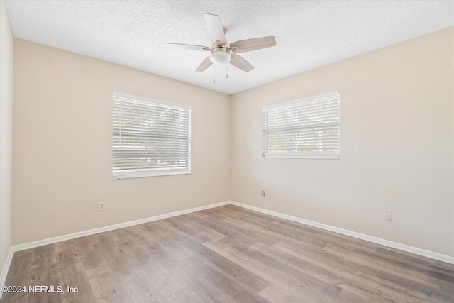 empty room featuring ceiling fan, a textured ceiling, and light wood-type flooring