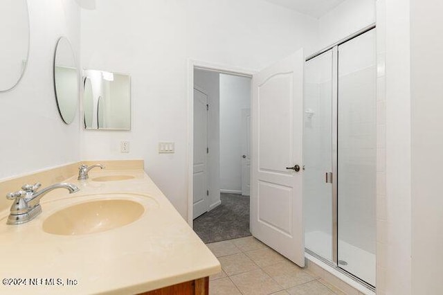 bathroom with tile patterned flooring, vanity, and a shower with shower door