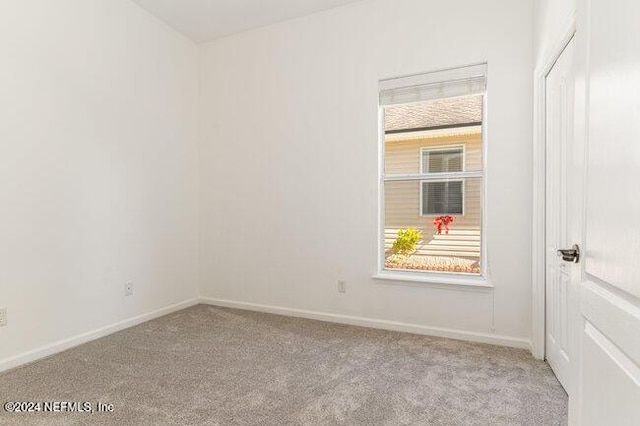 spare room featuring light colored carpet