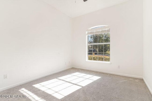 spare room featuring light carpet and ceiling fan