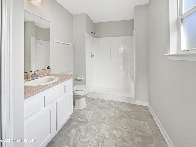 bathroom featuring tiled shower, vanity, and toilet