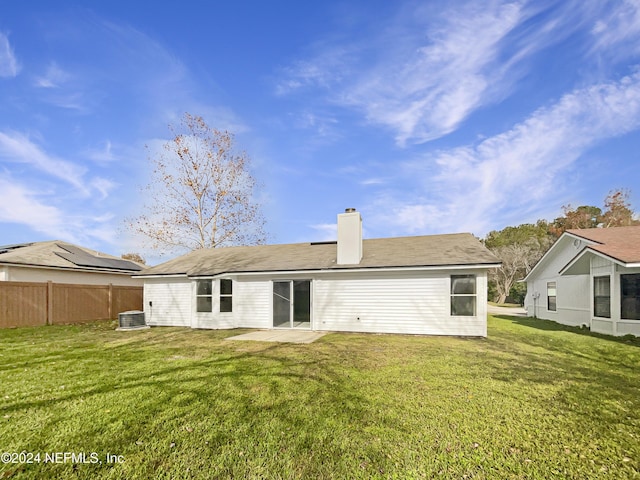 back of house with central AC, a patio area, and a lawn