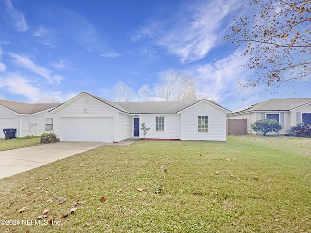 ranch-style house with a garage and a front lawn