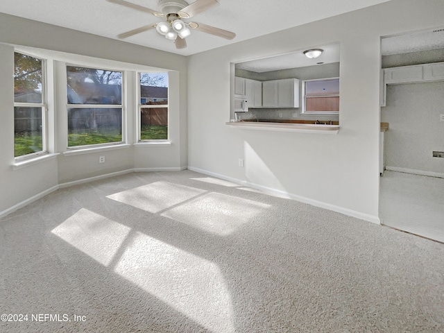 unfurnished living room featuring light colored carpet and ceiling fan