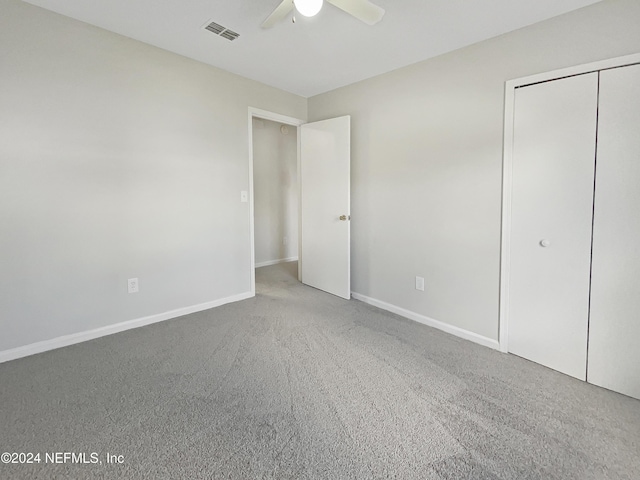 unfurnished bedroom with carpet flooring, ceiling fan, and a closet